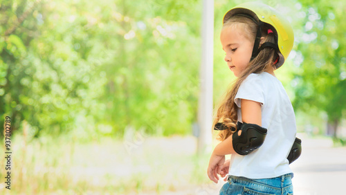 Girl skateboard with safety equipment - helmet, knee and elbow pads. Safe summer activity. Kids activity.