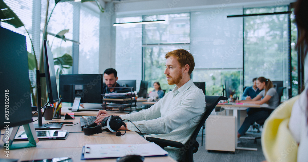 Camera sliding in front of people sitting at desks. Caucasian workers focused during their busy working hours. Typing on keyboard. Answering calls through headset. Camera sliding in front of people sitting at desks. Caucasian workers focused during their busy working hours. Typing on keyboard. Answering calls through headset.