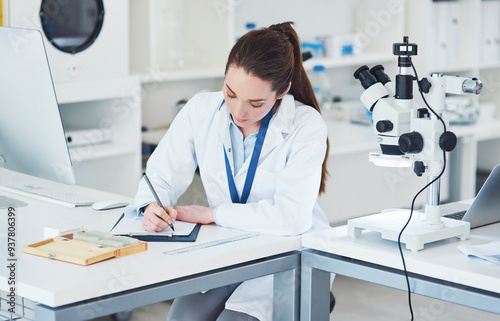 Microscope, scientist and writing notes for medical research in laboratory with biology or pharmaceutical results. Female person, technology and analysis for pathology, science and vaccine innovation