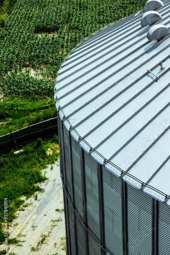 Obraz na płótnie Close-up of large grain storage silos with precision-engineered metal roofs. Essential for high-capacity agricultural storage facilities. Vertical photo w salonie
