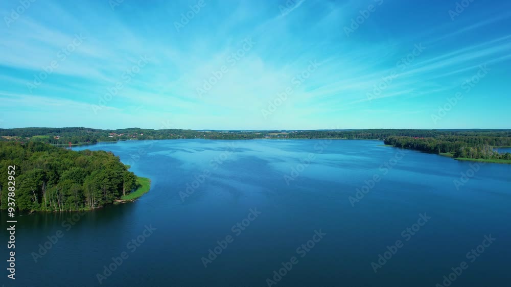 Beautiful Lake With Islands is Surrounded by Trees and Houses. Sky is Clear Sun is Shining. Majestic Aerial View of Calm Lake With Islands in Europe. Village Houses on Shore of Paradise Place Lake. Beautiful Lake With Islands is Surrounded by Trees and Houses. Sky is Clear Sun is Shining. Majestic Aerial View of Calm Lake With Islands in Europe. Village Houses on Shore of Paradise Place Lake.