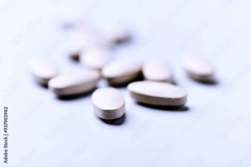 Ashwagandha (Withania somnifera) tablets. Concept for a healthy dietary supplementation. Bright paper background. Close up. Copy space.