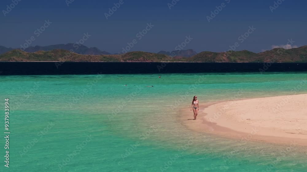 Aerial drone view of woman walking on a tropical wild beach island in Philippines. Travel video of tourist woman relaxing and enjoying beach paradise during summer holiday Aerial drone view of woman walking on a tropical wild beach island in Philippines. Travel video of tourist woman relaxing and enjoying beach paradise during summer holiday