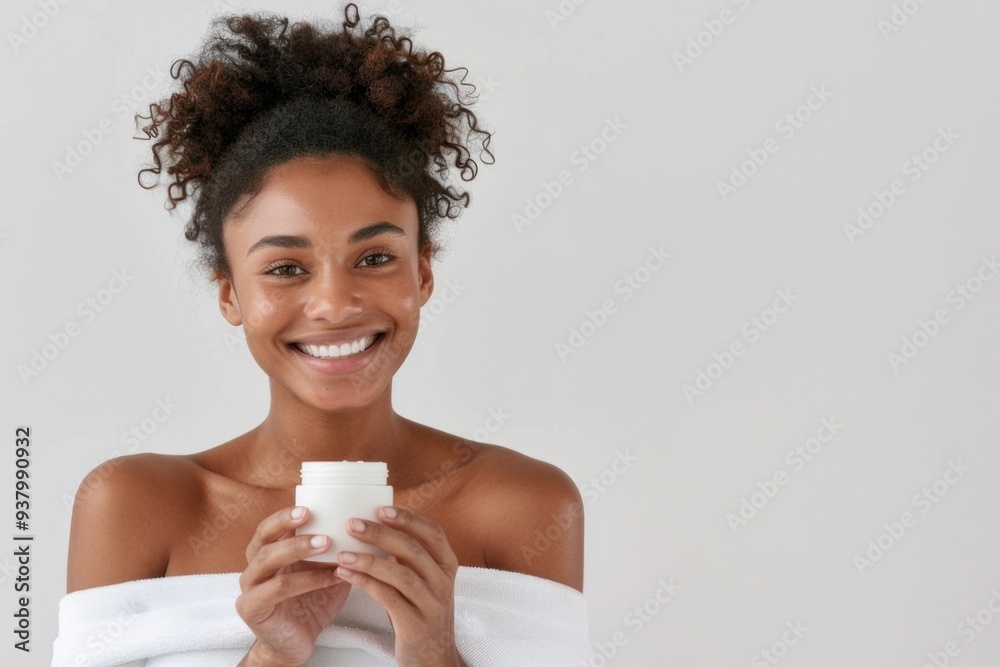 A woman is holding a white jar of cream in her hand