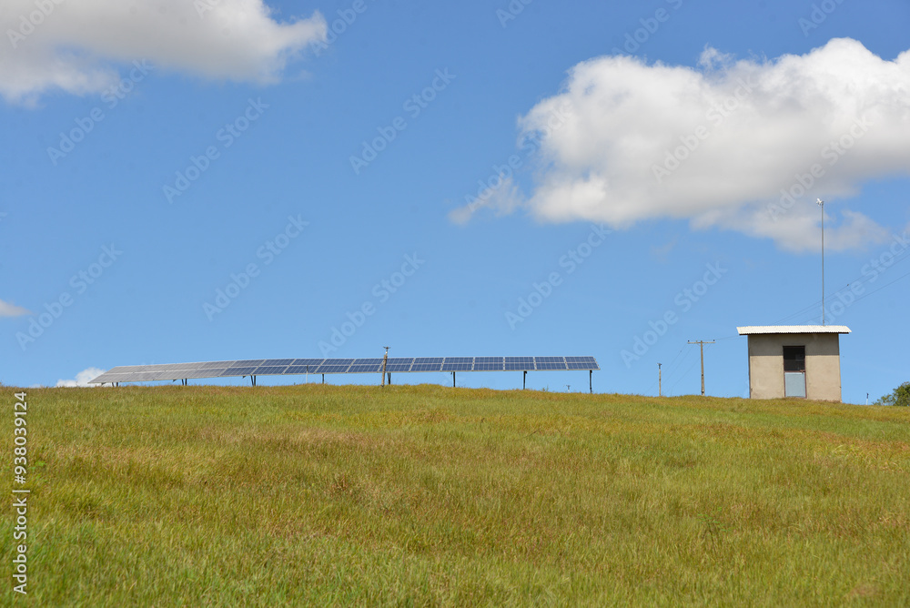 Open space solar panels installation with photovoltaic modules on a hay field in rural farm on sunny day. Open space solar panels installation with photovoltaic modules on a hay field in rural farm on sunny day.