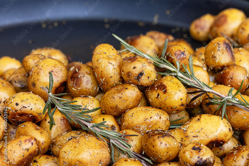 Close-up of roasted potatoes seasoned with a blend of aromatic herbs and spices, drizzled with olive oil, and garnished with rosemary and salt. Food concept Close-up of roasted potatoes seasoned with a blend of aromatic herbs and spices, drizzled with olive oil, and garnished with rosemary and salt. Food concept