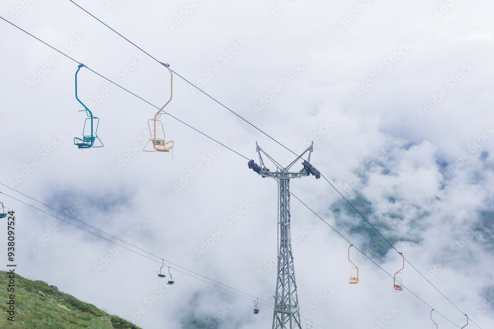 chairlift over mountain slope in cloudy weather chairlift over mountain slope in cloudy weather