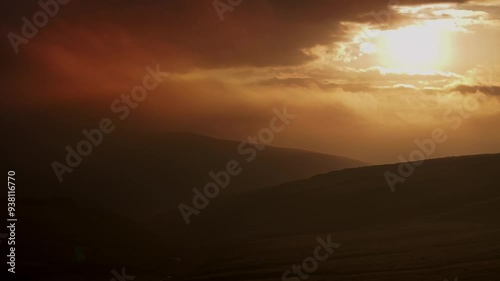 A beautiful sunrise over the valley of Arncliffe  casts a golden glow over rolling hills, with rays of light streaming through clouds, creating a serene and tranquil atmosphere in nature's landscape. photo