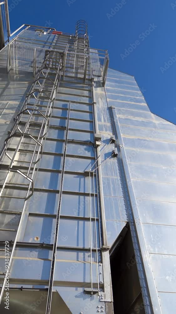 Industrial part of manufacture at sunlight. Modern industrial plant on blue sky background. Exterior of a new building for agribusiness. Vertical video Industrial part of manufacture at sunlight. Modern industrial plant on blue sky background. Exterior of a new building for agribusiness. Vertical video