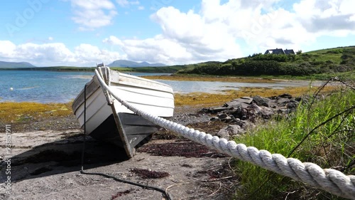 Picturesque scene showing a boat tied up along the shore on a sunny day. Clew Bay, Mayo, Ireland.