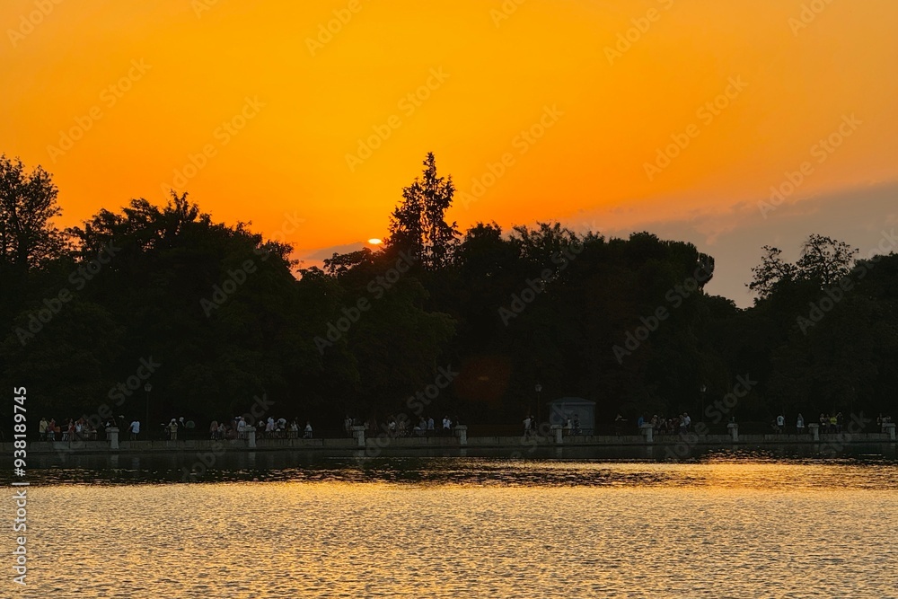 Beautiful sunset with golden sky in front of a lake in Madrid, Spain