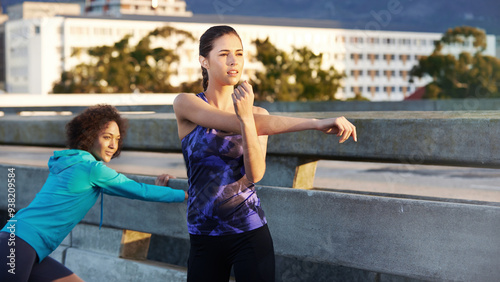 Woman, friends and stretching with fitness in city for workout preparation, training or outdoor exercise. Active, young and female person getting ready in warm up for cardio or run in an urban town