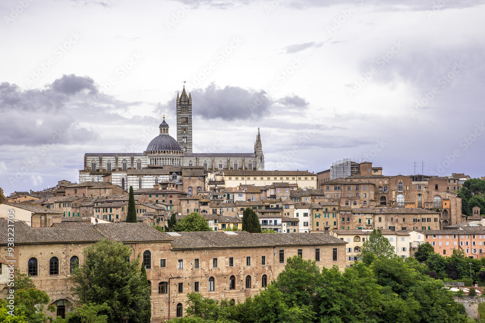 Naklejka premium Ogólna panorama Sienny w letnie pochmurne popołudnie z widokiem katedry na pierwszym planie