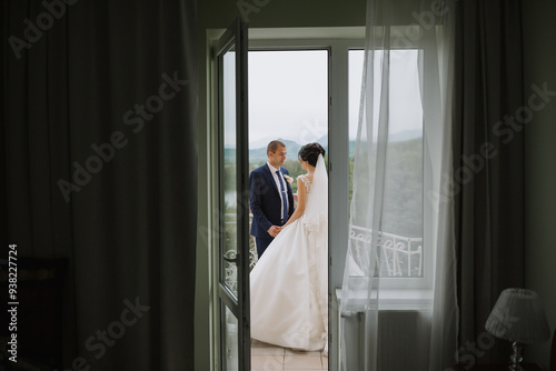 Konstfotografi A bride and groom are standing in front of a window