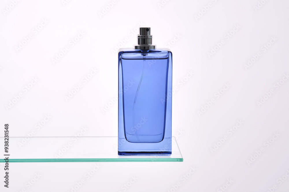 Perfume spray in a blue bottle on a white background. Perfume spray in a blue bottle on a white background.