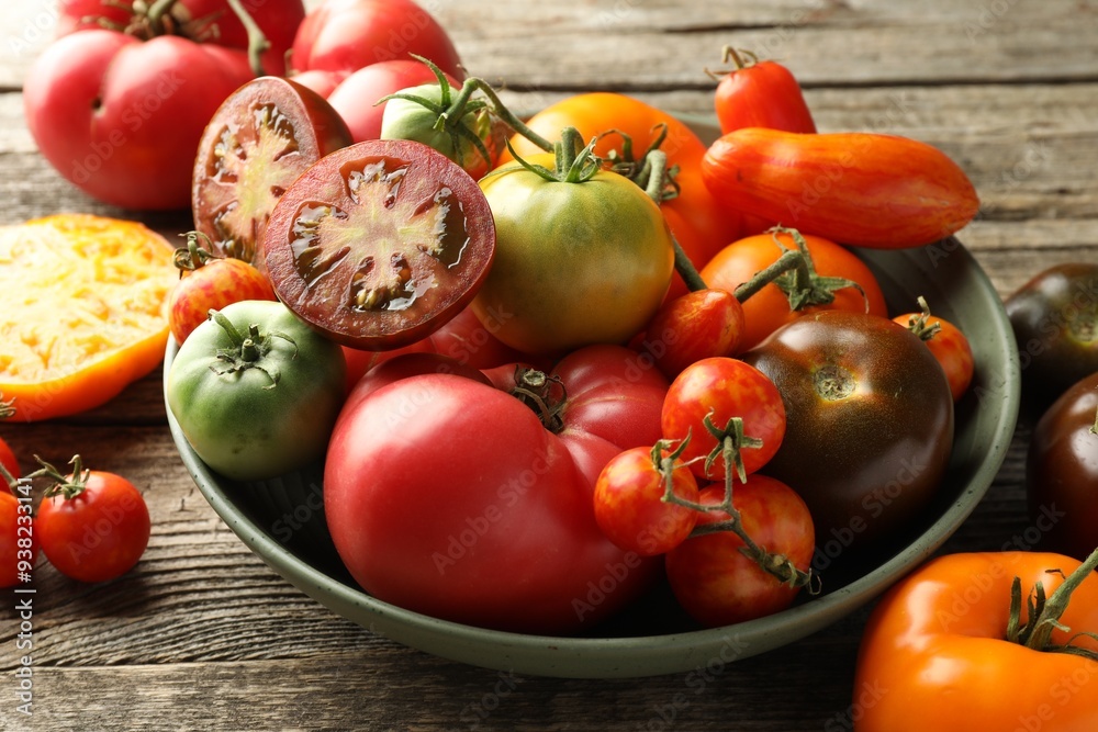 Different ripe tomatoes in bowl on wooden table, closeup Different ripe tomatoes in bowl on wooden table, closeup