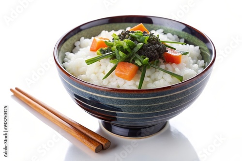 Delicious Japanese Rice Bowl with Caviar and Vegetables - A bowl of white rice topped with caviar, chopped vegetables, and a few slices of orange carrot. The bowl is made of dark green and brown potte