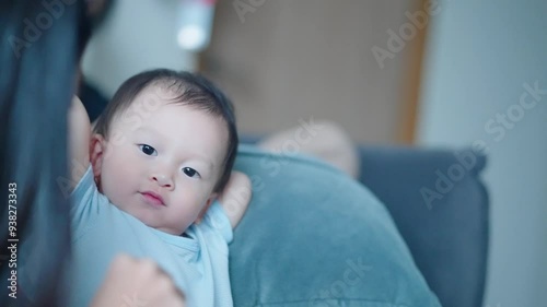 Asian child and his baby sitter doing indoor activity together at home living room couch, child story telling method, cartoon books, kids entertainment, learning from reading, childhood home education