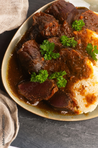 Stewed goose stomach.  Traditional Polish meat on a dark background.