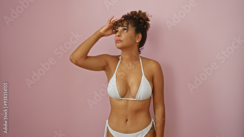 Fotografie Beautiful latina woman in a white bikini posing confidently over an isolated pin