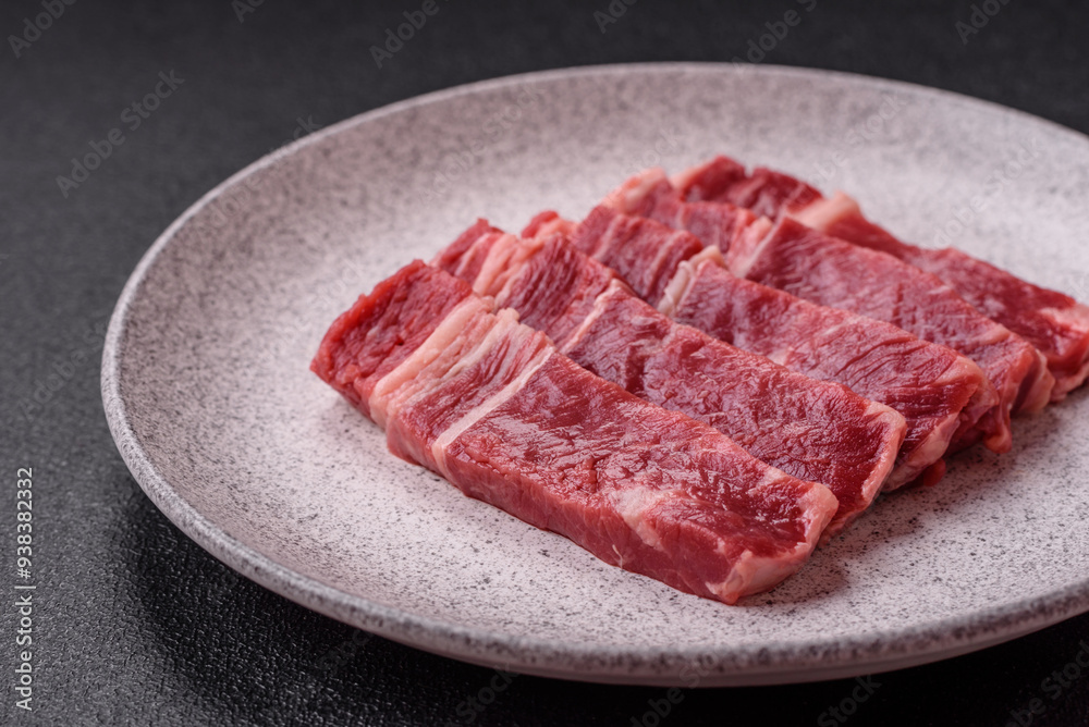 Fresh raw beef cut into slices with salt, spices Fresh raw beef cut into slices with salt, spices