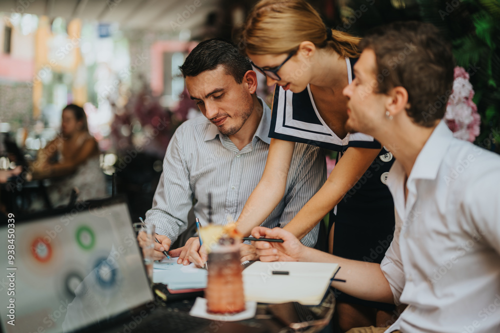 Fototapeta premium A team of professionals working together in an outdoor cafe setting. They are engaged in discussion and collaboration during a casual business meeting, enhancing creativity and teamwork.