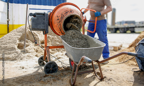 Cuadro en lienzo Constriction worker making concrete in an orange mixer