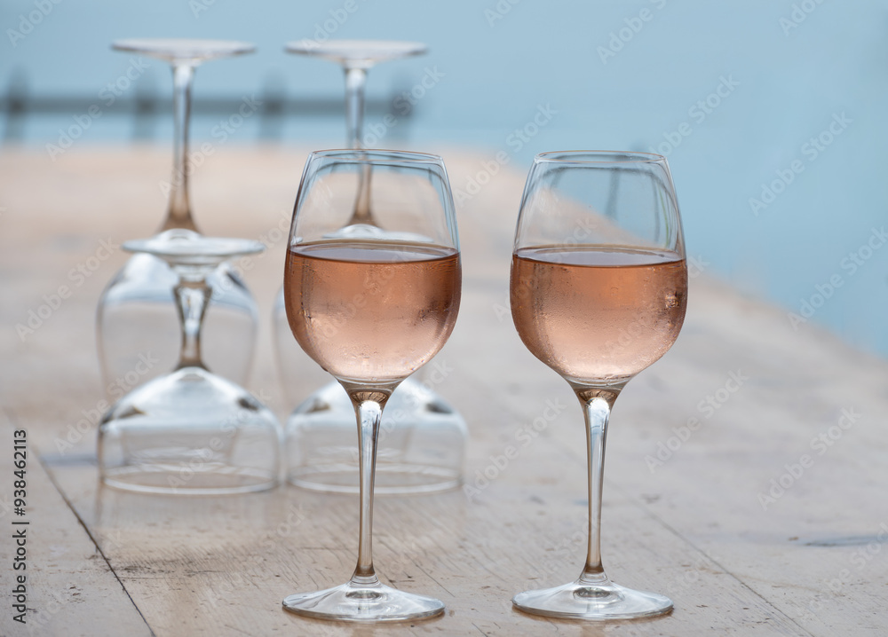 Summer time in Provence, two glasses of cold rose wine with blue sea view on background, French Riviera near Menton, south of France Summer time in Provence, two glasses of cold rose wine with blue sea view on background, French Riviera near Menton, south of France