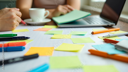 A group engages in an idea generation session using vibrant sticky notes while sipping coffee, surrounded by writing tools and a laptop in a warm workspace