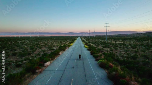 Drone shot of motorcyclist riding off into the distance