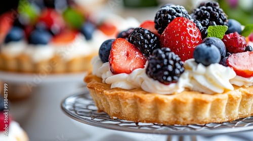 This tempting berry tart features a delectable combination of whipped cream, fresh strawberries, blueberries, and blackberries, all beautifully presented with a mint garnish.