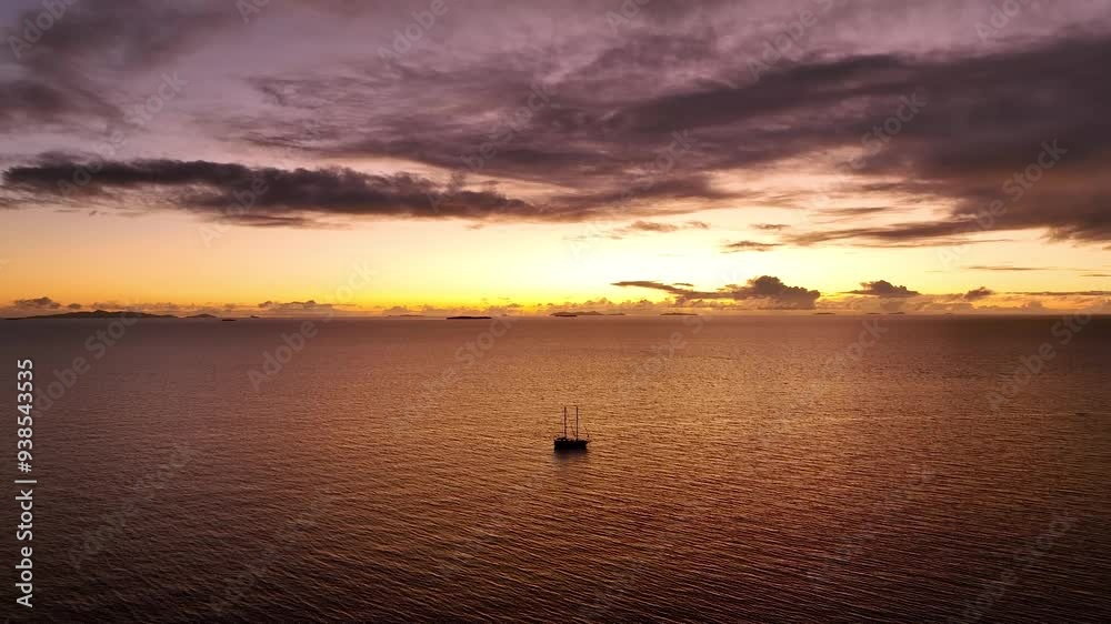 Silhouette of a yacht against the backdrop of a colorful tropical sunset sky at the sea and Fiji Island. Sunset, blue and orange clouds flow in sky. Summer landscape. Exploring world, travel, holidays Silhouette of a yacht against the backdrop of a colorful tropical sunset sky at the sea and Fiji Island. Sunset, blue and orange clouds flow in sky. Summer landscape. Exploring world, travel, holidays