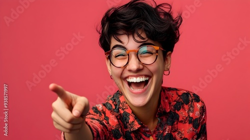 An energetic and joyful man laughing heartily while enthusiastically pointing forward with a cheerful friendly expression on his face