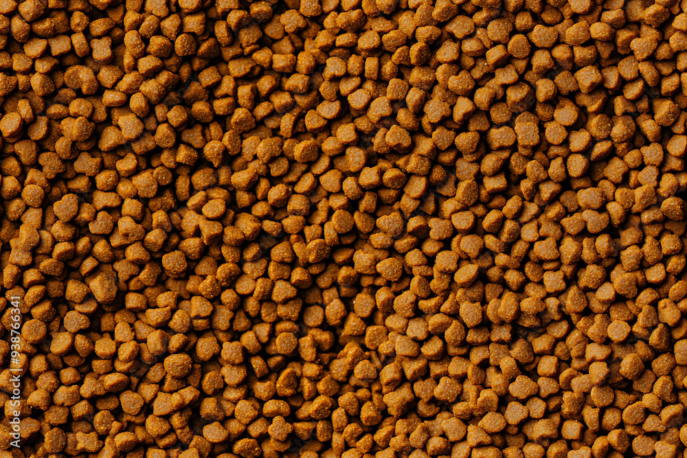 A close-up image of a bowl filled with dry pet food kibble, showcasing the texture and detail of the crunchy pellets.
