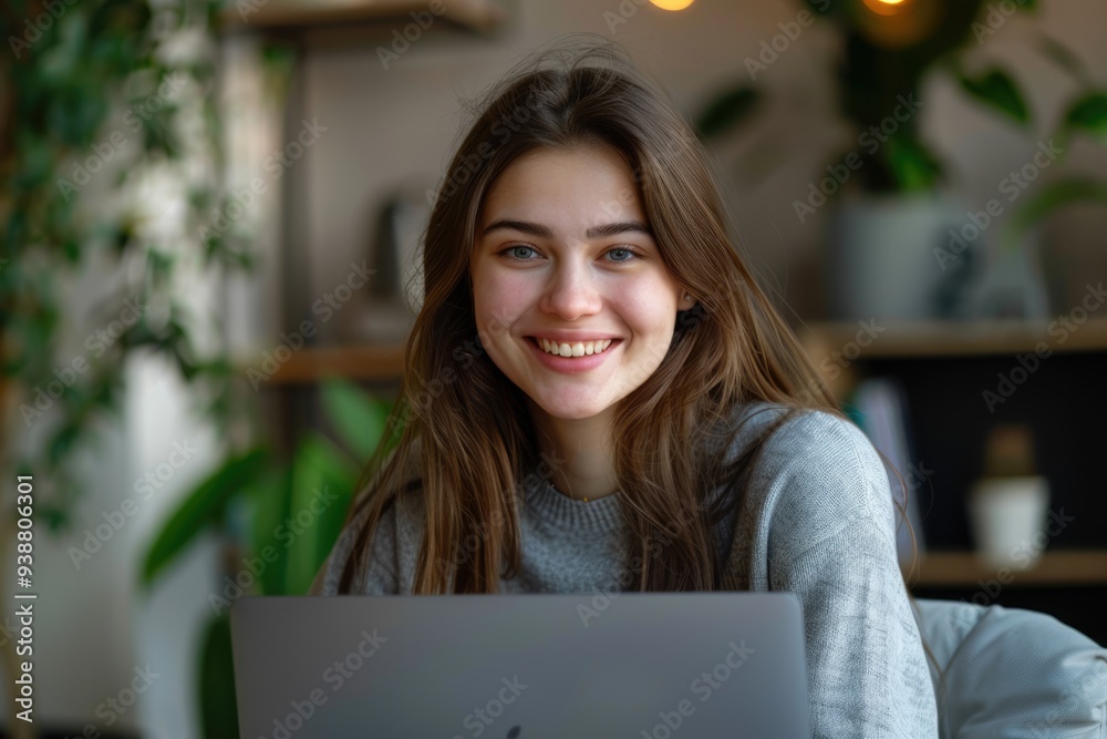 Young woman smiling while working on laptop in office. Young woman smiling while working on laptop in office.