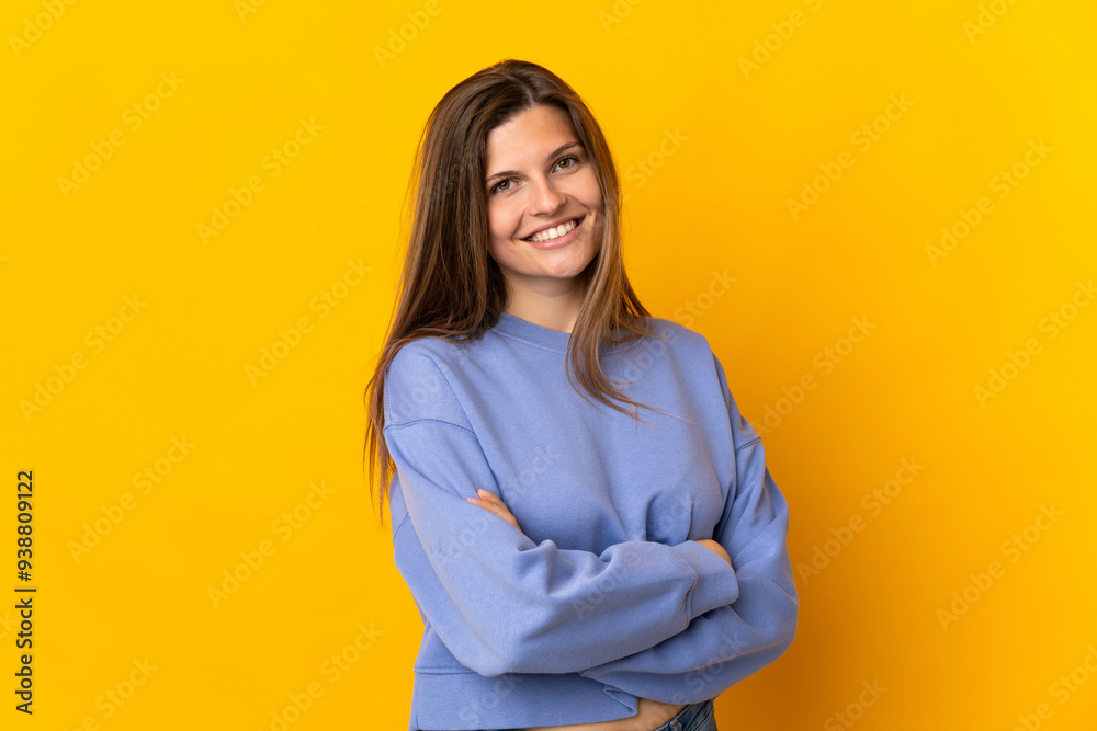 Young Slovak woman isolated on yellow background with arms crossed and looking forward Young Slovak woman isolated on yellow background with arms crossed and looking forward