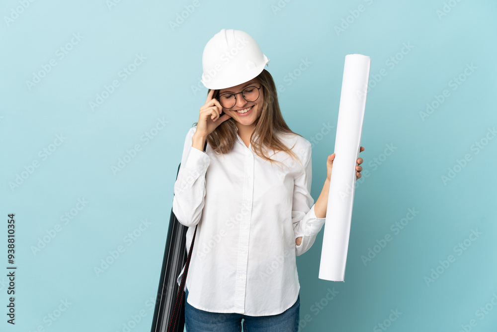 Slovak architect girl holding blueprints isolated on blue background laughing