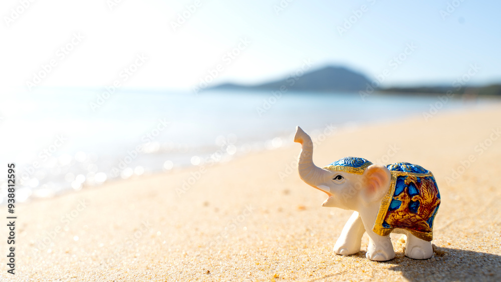 Obraz premium figurine of an elephant on the beach by the sea. concept of travel and tourism on vacation