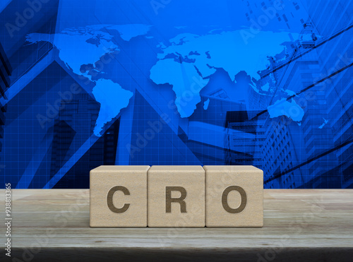 Fototapeta Naklejka Na Ścianę i Meble -  CRO acronym on wood block cubes on wooden table over world map, modern office city tower and skyscraper, Conversion Rate Optimization concept, Elements of this image furnished by NASA