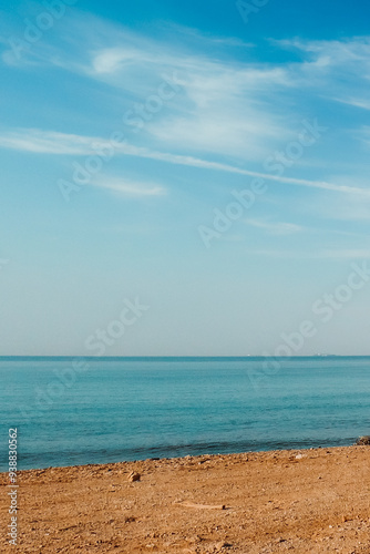 Al Ain Al Sokhna beach, Suez, Egypt, with a clear blue sky and calm sea, meeting the sandy shore