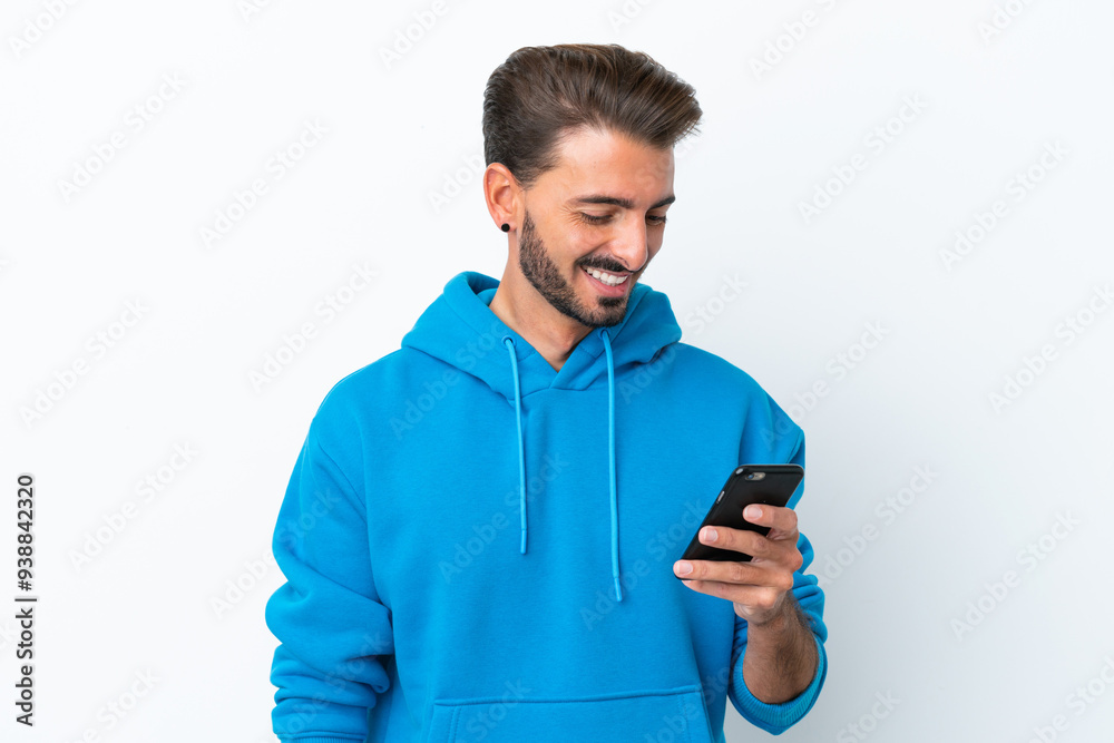 Young caucasian man isolated on white background sending a message or email with the mobile Young caucasian man isolated on white background sending a message or email with the mobile