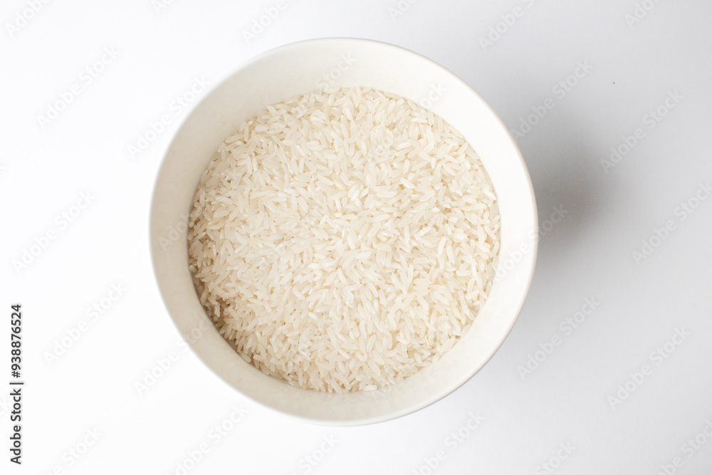A ceramic bowl filled with uncooked white rice on a white background, optimal for illustrating concepts of basic nutrition or Asian cuisine preparation A ceramic bowl filled with uncooked white rice on a white background, optimal for illustrating concepts of basic nutrition or Asian cuisine preparation