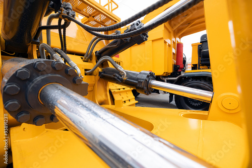 Pneumatic hydraulic piston for industry machinery technology. Concept chrome plated cylinder shaft of yellow bulldozers, tractors, excavators for lifting