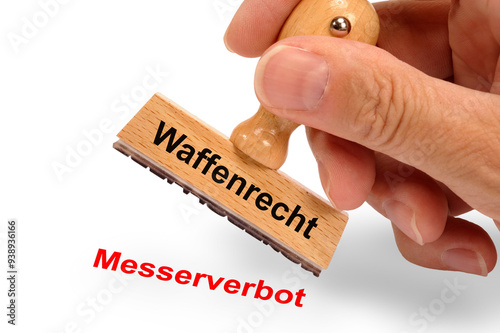 Ein Holzstempel ist beschriftet mit dem Aufdruck: Waffenrecht und dem Abdruck Messerverbot photo