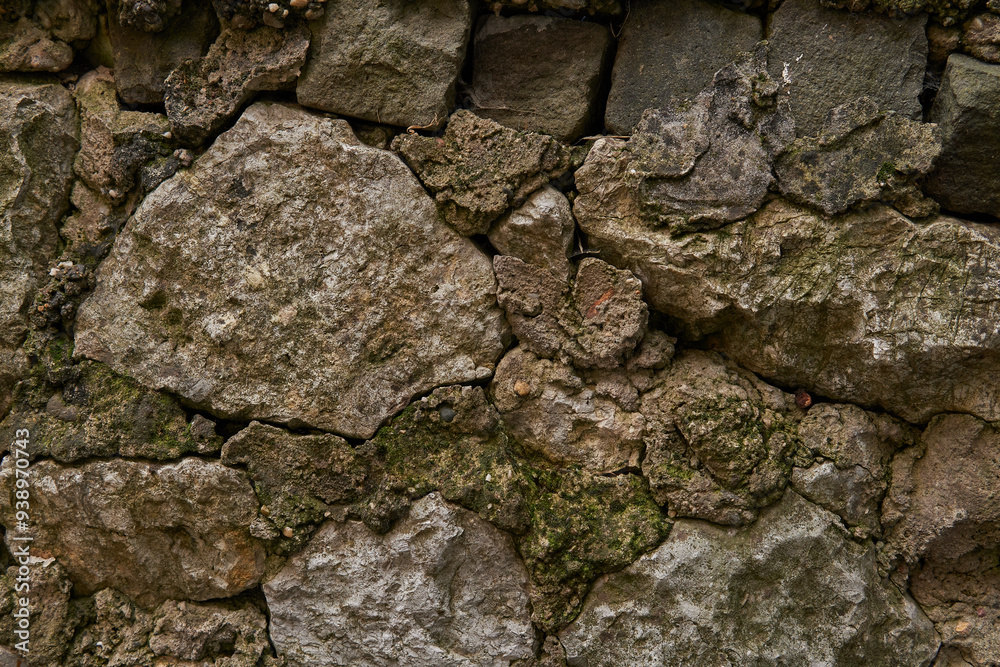 Old stone wall texture with green foliage background pattern Old stone wall texture with green foliage background pattern