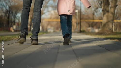 Wallpaper Mural Focused view of a little girl and an adult man's legs walking together on a park pathway, both wearing blue jeans and black shoes in daylight Torontodigital.ca