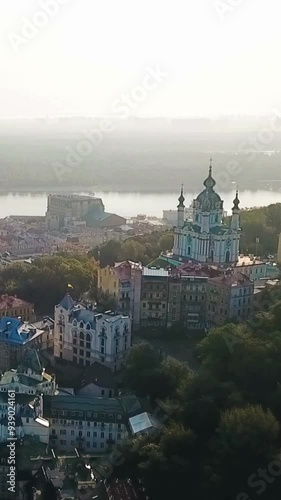 aerial video footage Kyiv capital of Ukraine. camera flies over St Andrew's Church and Andriivskyi Descent. Sunrise soft summer backlight. Vertical video footage  photo