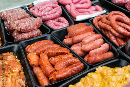 raw meat for sale in a butcher shop. There is spicy chorizo, sweet chorizo, sausages, red meat and spicy chicken photo