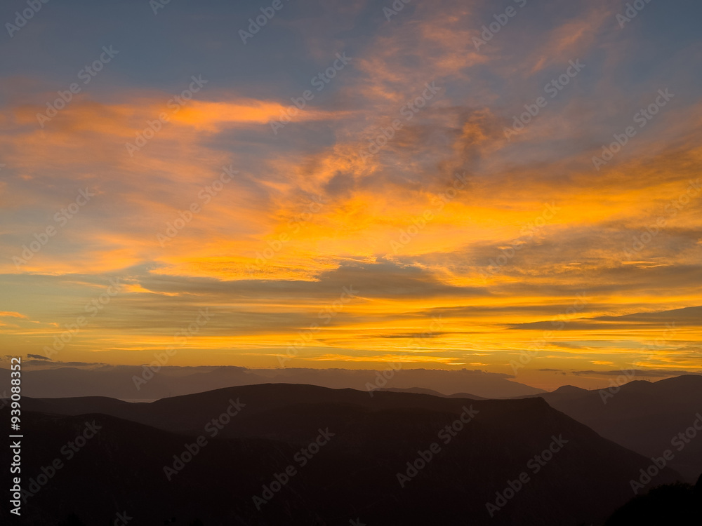 Sunrise, sunset over the silhouette of mountains. Dramatic colorful sky with clouds Sunrise, sunset over the silhouette of mountains. Dramatic colorful sky with clouds