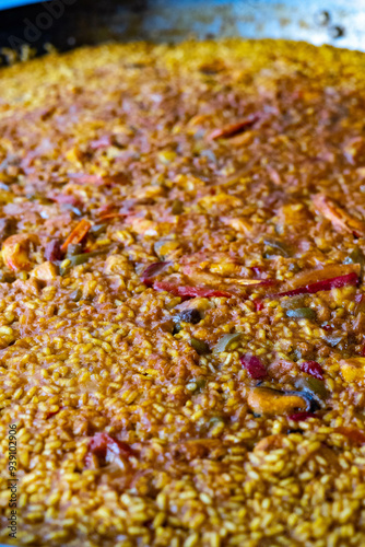closeup of typical Spanish seafood paella, made with rice, seafood, pepper, saffron.